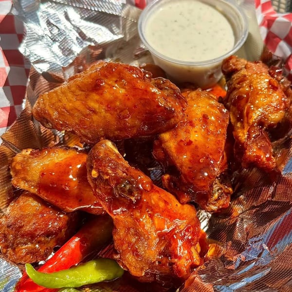 Mama Noi's Asian-fusion chicken wings with a sweet glaze, peppers, and a side of ranch.
